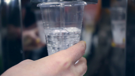 水流入塑料杯手持水杯的特写镜头视频
