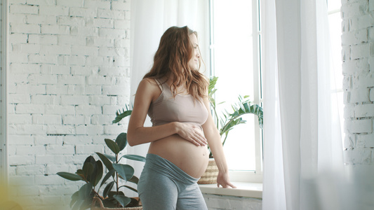 孕妇在窗前抚摸肚子视频