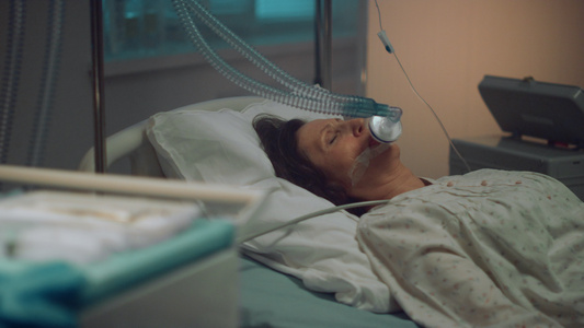 带着氧气面罩的病人躺在空荡荡的医院病房里视频