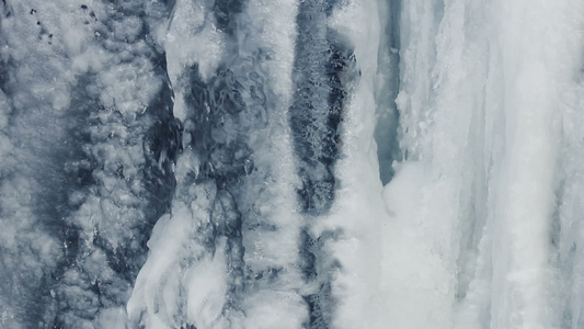 冰背景冰面冰冷的瀑布水在冰下流动闭合视频