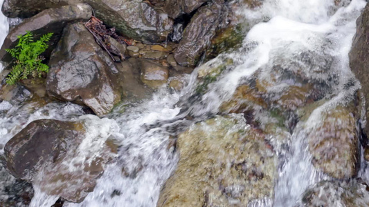 水流在石头上小水滴落在岩石上石头间流动的水视频