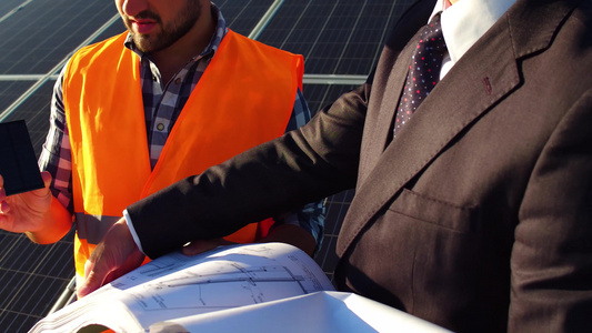 工人和商人对讨论项目的看法他们的背后是太阳能电池板视频