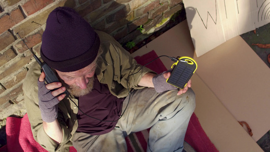 使用光电元件充电手机的无家可归的人他们用太阳能来充电视频