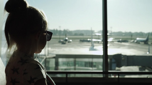 日落时小女孩坐在机场客运大楼等候区14秒视频