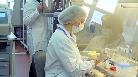 在实验室工作的妇女化学家与玻璃瓶一起工作化学研究视频