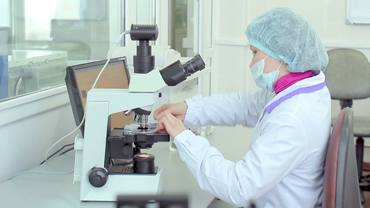 在实验室通过显微镜检查女研究员视频