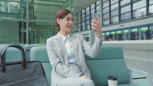 商务女性机场候机厅使用手机视频通话视频