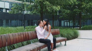 年轻多种族夫妇坐在板凳上接吻的缩影拍摄12秒视频