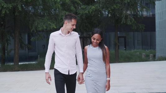 两个多种族的爱人走在街上互相拥抱和交谈彼此交待视频