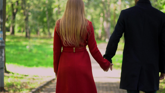 情侣在公园散步时手牵手视频