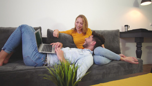 情侣在沙发上相爱笔记本电脑笑着男孩躺在女孩腿上11秒视频