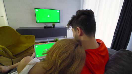 用绿色屏幕笔记本电脑和电视机的一对夫妇视频