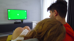 两对夫妇在客厅里带着绿色屏幕电视女孩抱抱男孩12秒视频