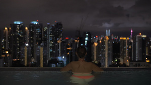 一对夫妇在屋顶泳池看夜景53秒视频