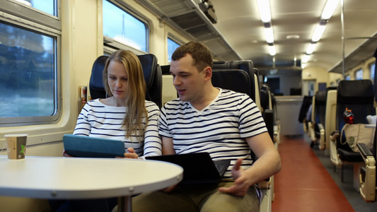 火车上有女人和男人用笔记本电脑说话视频
