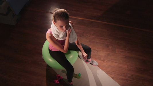 女人在健身房锻炼时擦拭汗水视频