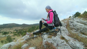 年轻女子在高山高原上徒步饮水坐在悬崖悬崖13秒视频