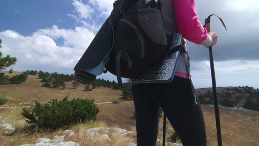 年轻女白天在通往山高地的路上徒步旅行视频