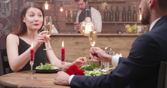 相爱的情侣坐在餐厅的餐桌边喝香槟视频