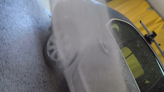 在车库车辆表面喷洒清洁剂泡沫的高压洗涤车视频