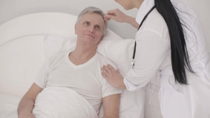 医生照顾在床上的残疾老年男子15秒视频