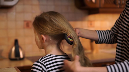 女儿长金发长发在舒适的木制厨房家穿着条纹衣服的彩色视频