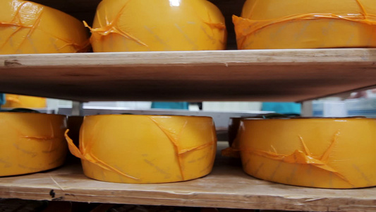 工厂仓库货架上包装的奶酪轮子视频