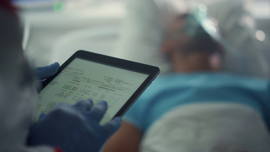 医生拿着平板电脑屏幕在病房特写检查病人的病史视频