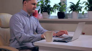 坐在现代办公桌上的男子在笔记本电脑上打字22秒视频
