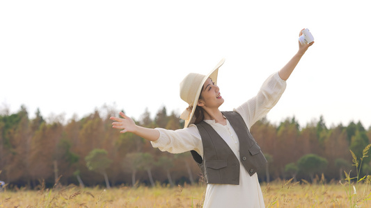 美女在金黄色稻田里开心拍照视频