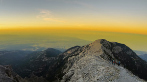 登山者从岩石峰顶上下来时的日落16秒视频