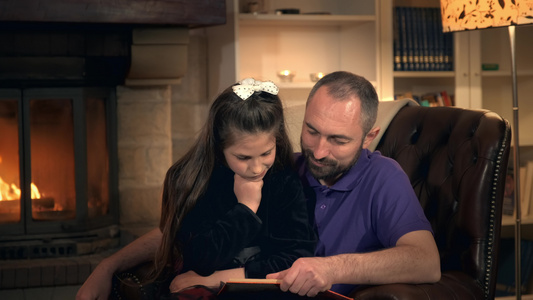 爸爸在晚上的壁炉旁读他的小公主一个童话故事视频