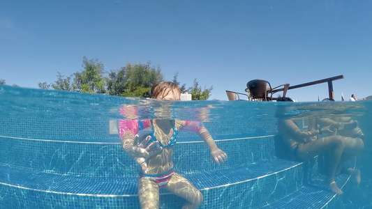 女孩追逐和扑击相机慢动作半在水下拍摄掌声在热泳池里视频
