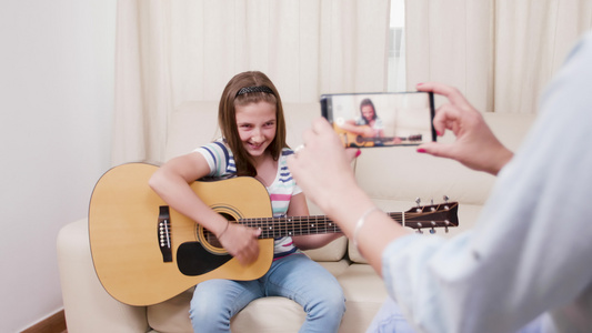 母亲制作了一个视频她年轻女儿弹奏的音乐吉他视频