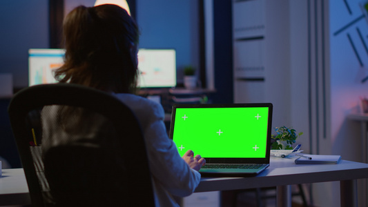 商业女性观看绿色屏幕笔记本电脑的后视线视频