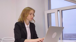 坐在办公室和笔记本电脑上工作着的美丽的精致女白领13秒视频
