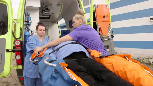 救护人员在救护车担架上为女性病人提供救助视频