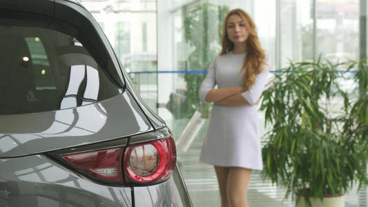 在经销商选择一辆新车的同时思考着美丽的女人视频