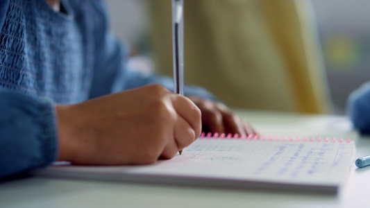 女孩在教室课桌的笔记本上写字在学校做功课视频