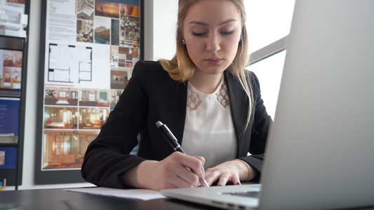 现代办公室的妇女创业者用笔业务在现代办公室桌上写字视频