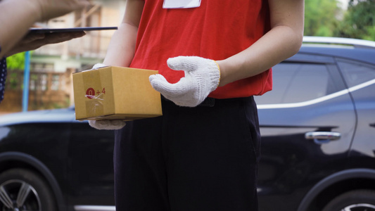送货员将包裹送到家中的年轻女顾客因此必须戴口罩以防止视频