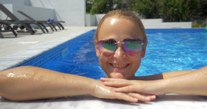 女人穿着太阳镜在泳池里享受阳光明媚的一天18秒视频