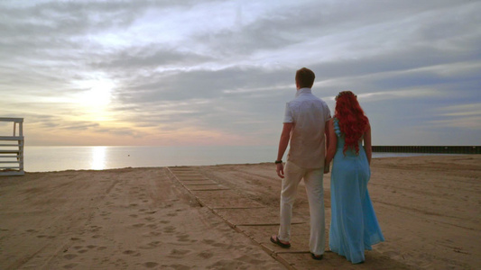 日出时在海边散步的情侣视频