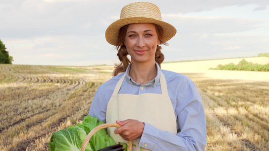 女农民草帽拿着篮子蔬菜洋葱番茄沙拉黄瓜站在农田微笑视频