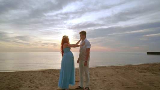 日出在海滩上怀孕的一对夫妇海边的男人和女视频