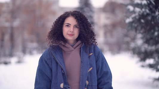 快乐的年轻女子在冬天的城市里带着卷发视频