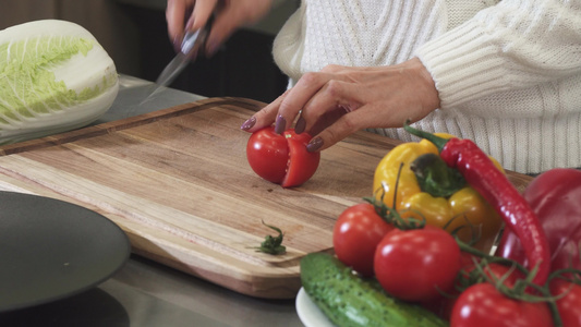 一个女人在木板上切番茄的近距离剪切镜头视频