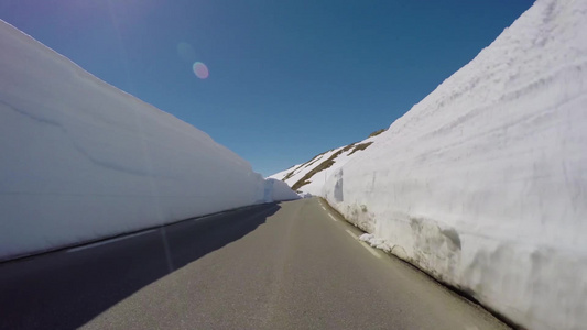 周围雪墙的山路上驾驶一辆汽车视频