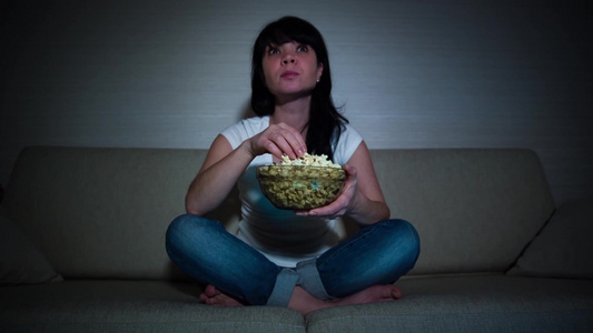 女人在沙发上看电影吃爆米花视频