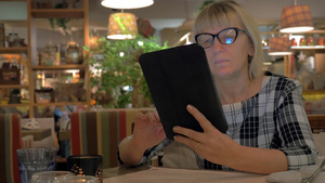 年长女性在咖啡馆里用平板19秒视频